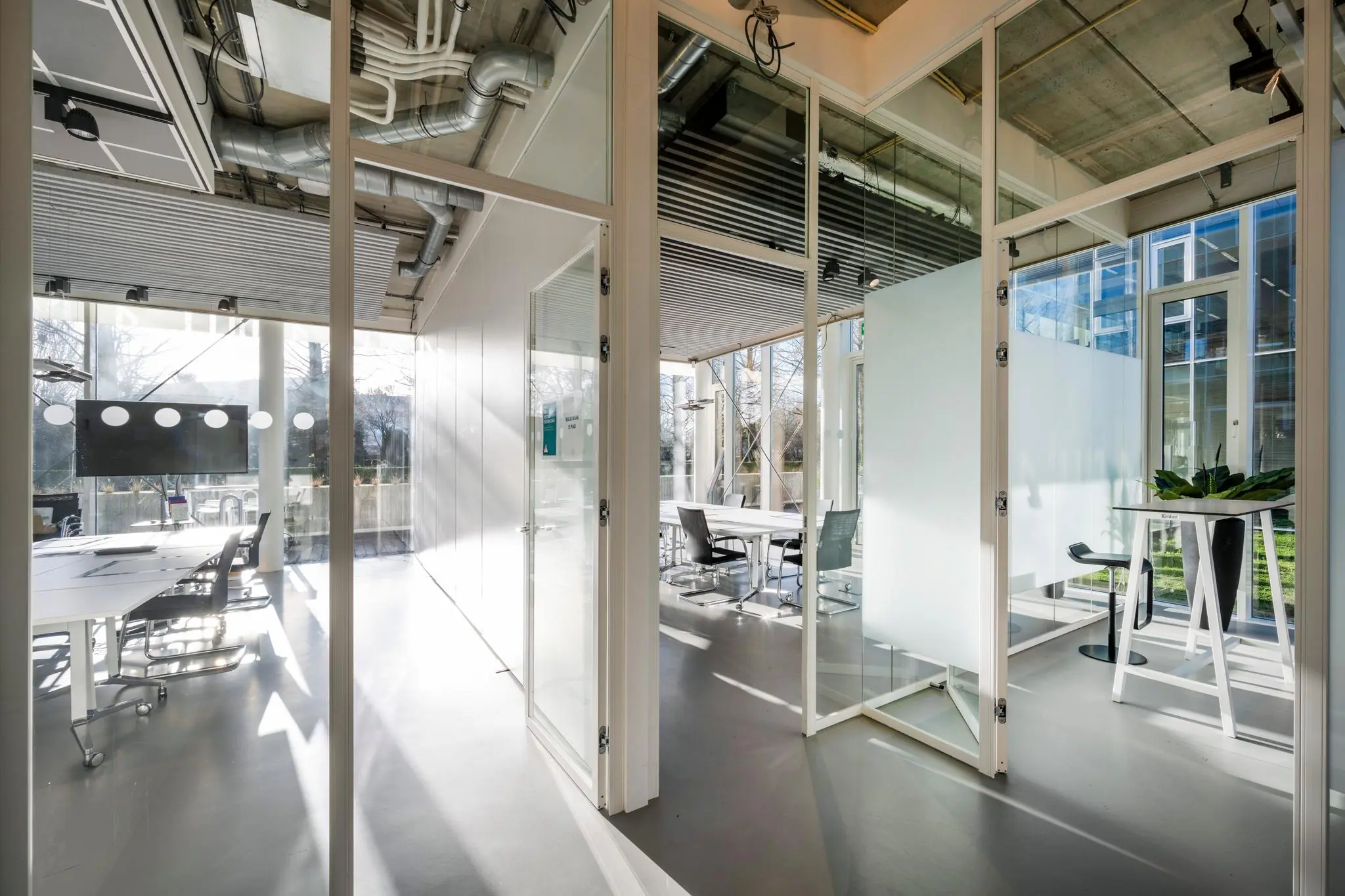 Moderne glazen vergaderruimtes met strak interieur aan de Fred. Roeskestraat, badend in natuurlijk daglicht.